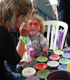 A photo of a child having their face painted