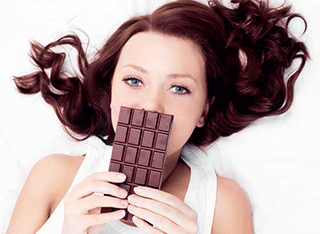A young woman with a bar of chocolate