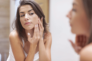 A photo of a woman cleansing her skin