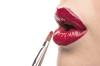 A woman applying lipstick
