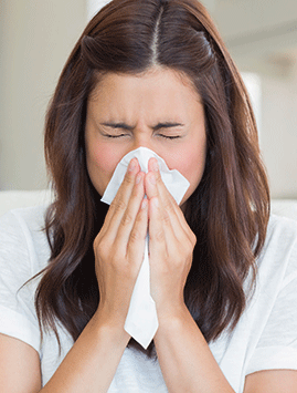 A woman blowing her nose