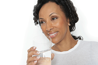 A woman holding a glass of water