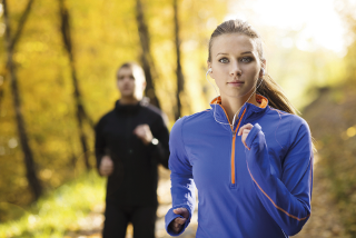 A photo of a couple running in a wood