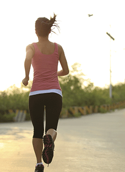 A photo of a woman running on a road